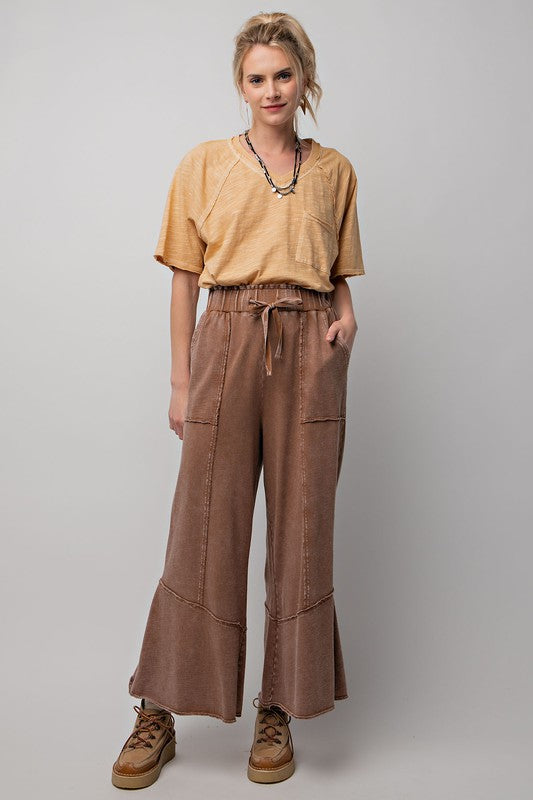 Kvinnors vida byxor av mineraltvättad frottéstickning i brun nyans, perfekt för en casual look på hösten.
