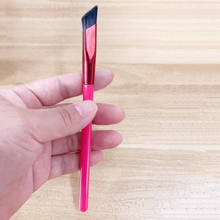 Kosmetikborste med ergonomiskt svart handtag för enkel applicering av ögonskugga och formning av bryn.
