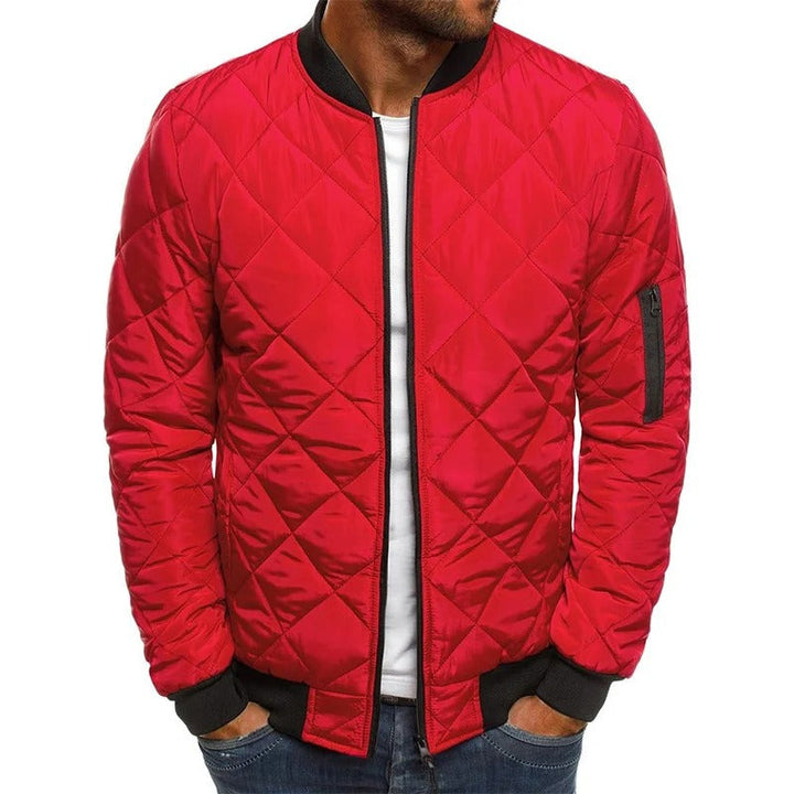 Snygg urbant mode med man bär quiltad bomberjacka, solglasögon och jeans, casual stil