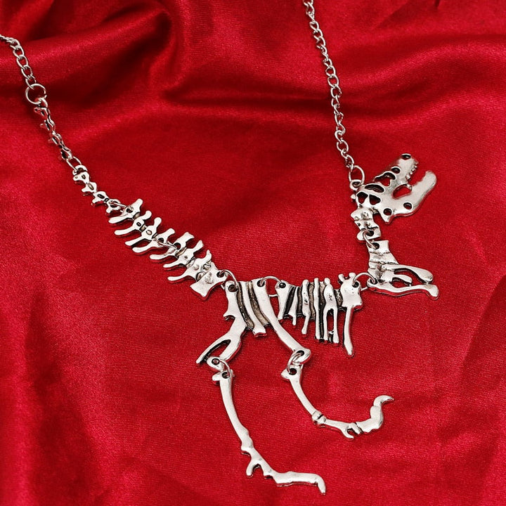 Unisex halsband med Tyrannosaurus Rex skelett, bärs på modell. Smycke i zinklegering, guld/brons.