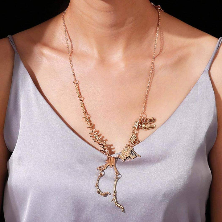 Hållbart unisex halsband med T-Rex skelett i zinklegering. Guld- och bronsfärgat dinosaurie smycke.