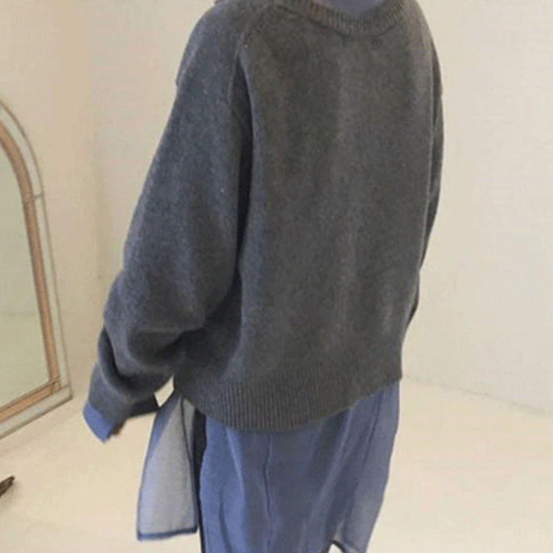 Modell bär en modern asymmetrisk damkardigan med knappdetalj, elegant och mångsidig för alla tillfällen.