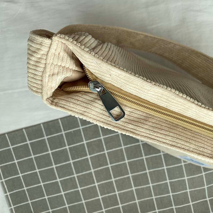 Praktisk kvinnohandväska i slitstark textil med rymliga fack och justerbar axelrem för komfort.