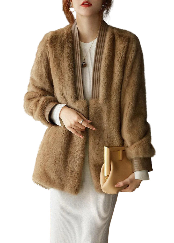 Elegant beige fuskpälskappa för dam. Långärmad, v-ringad design. Idealisk vinterkappa för fest och höstmode.
