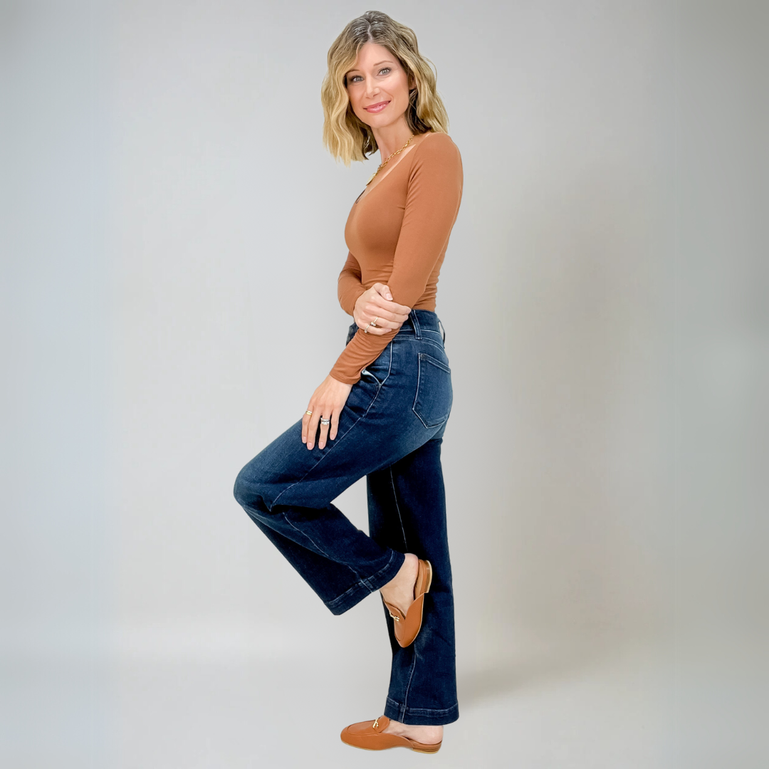 Närbild av textur på vida högmidjade damjeans i blå denim. Visar stretchmaterialet.