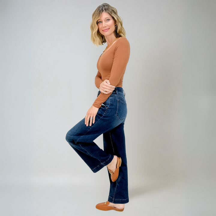Närbild av textur på vida högmidjade damjeans i blå denim. Visar stretchmaterialet.