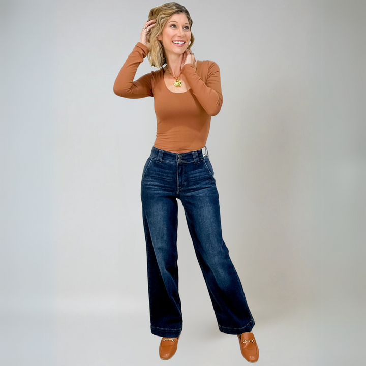 Modell bär bekväma vida jeans i blå denim med hög midja, idealiska för en elegant vardagslook.