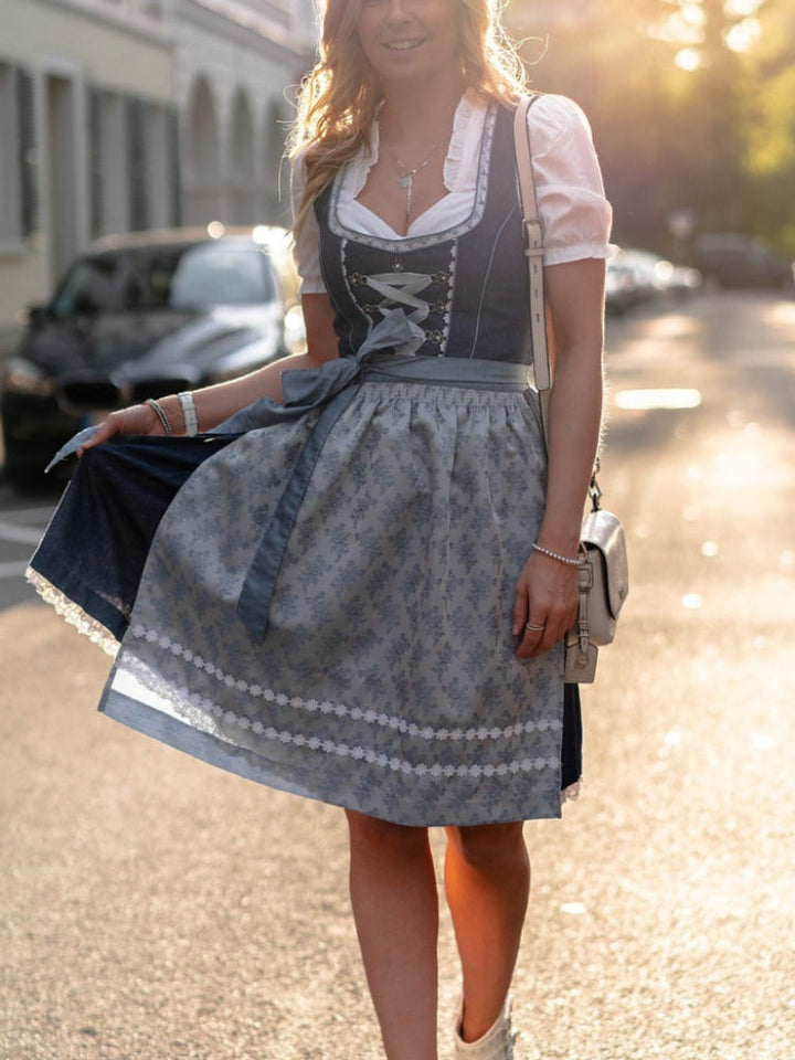 Traditionell blå dirndlklänning med vackert mönster och schürze, idealisk festklänning för Oktoberfest.