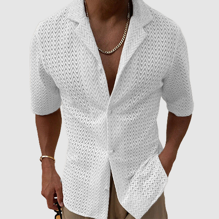 Man bär en kortärmad stickad herrskjorta i grått, matchar med shorts för en somrig look