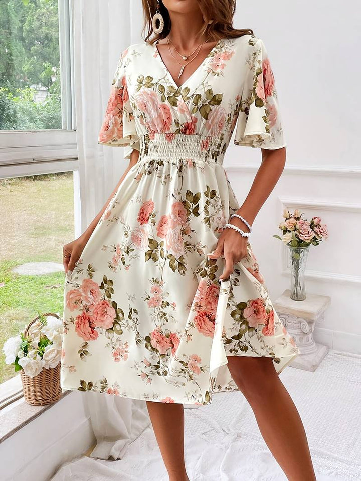 Kvinnors sommarklänning med blommigt mönster och v-ringning, en elegant A-linjemodell i polyester för semester.