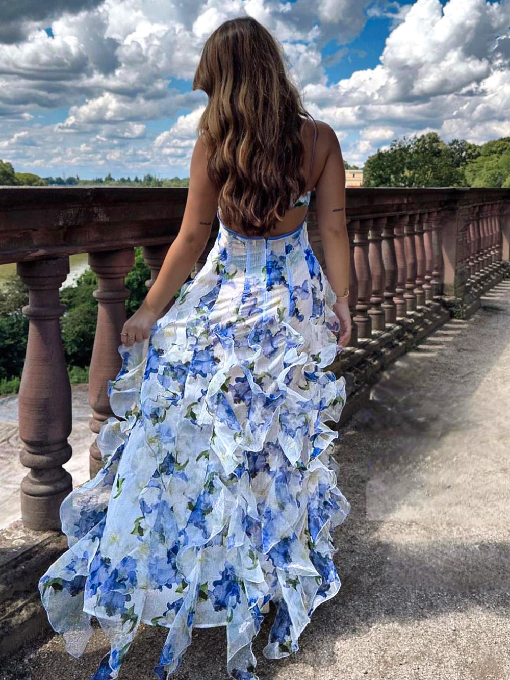 Detaljerad baksida av blommig volangklänning, visar eleganta volanger och färgrik design för kvinnor.