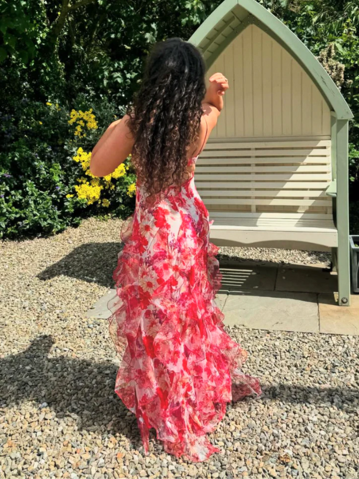 Kvinnors blommig volangklänning i rörelse, visar dess eleganta fall och luftiga design för sommarbruk.