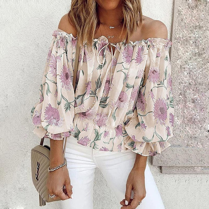 Trendig dam off shoulder-blus med vackert blommönster & volanger. Mångsidig överdel för vår & sommar.