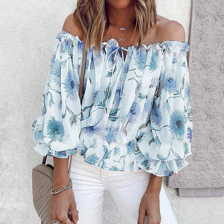 Blommig chiffongblus för dam med volangärm & off shoulder-design. Lätt & luftig sommartopp för stilmedvetna.