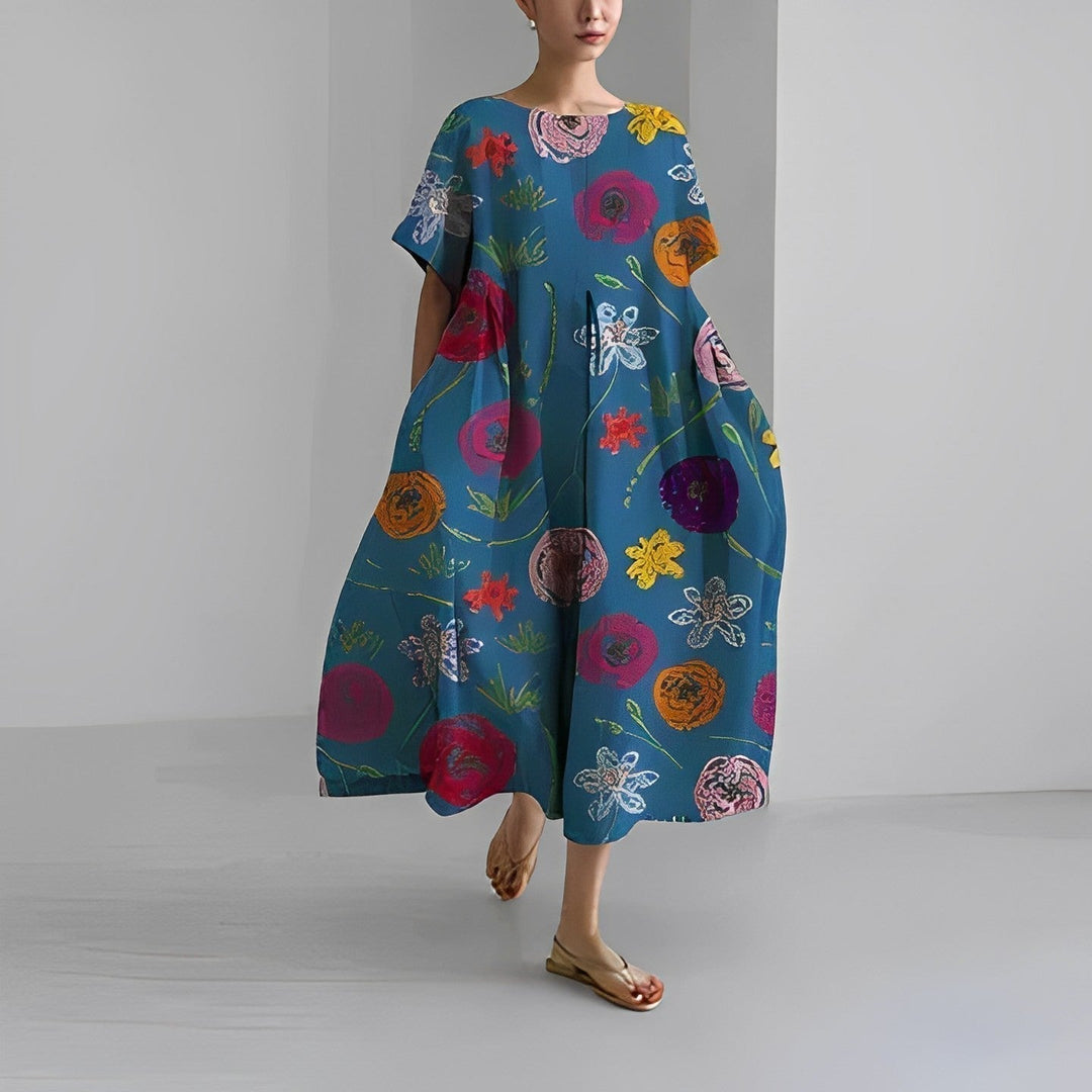 Kvinna poserar i elegant blommig sommarklänning. Lång, bekväm och mönstrad för en avslappnad semesterlook.