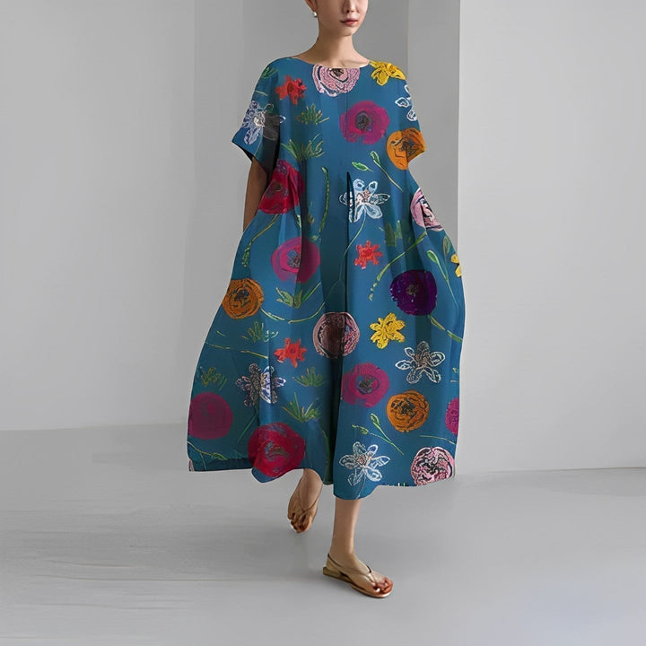 Kvinna poserar i elegant blommig sommarklänning. Lång, bekväm och mönstrad för en avslappnad semesterlook.