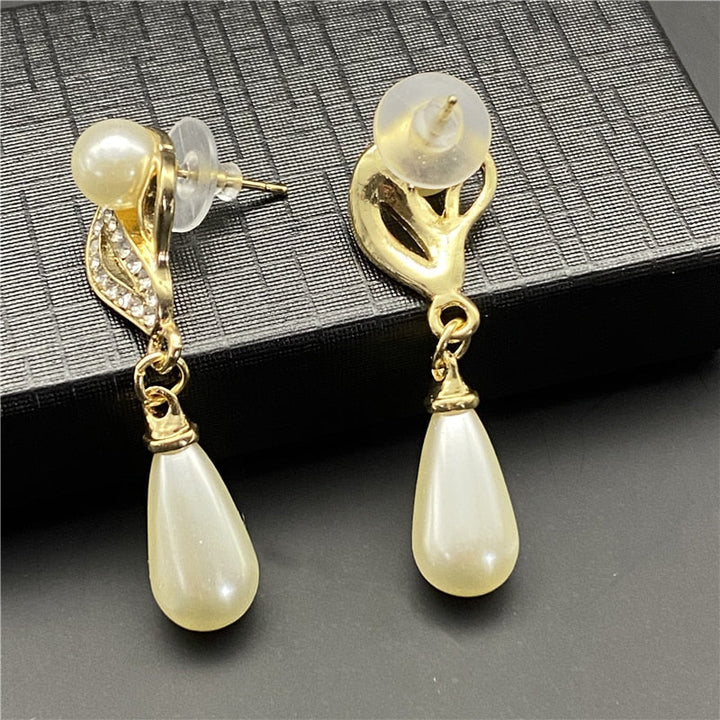 Dam bär elegant guldpläterat brudsmyckesset med strass & pärlor, vackra accessoarer för bröllop.