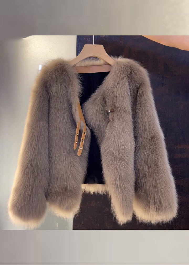 Beige damrock i läderstil med elegant v-hals och mjuka pälsdetaljer. Mångsidig vinterrock för stil och värme.