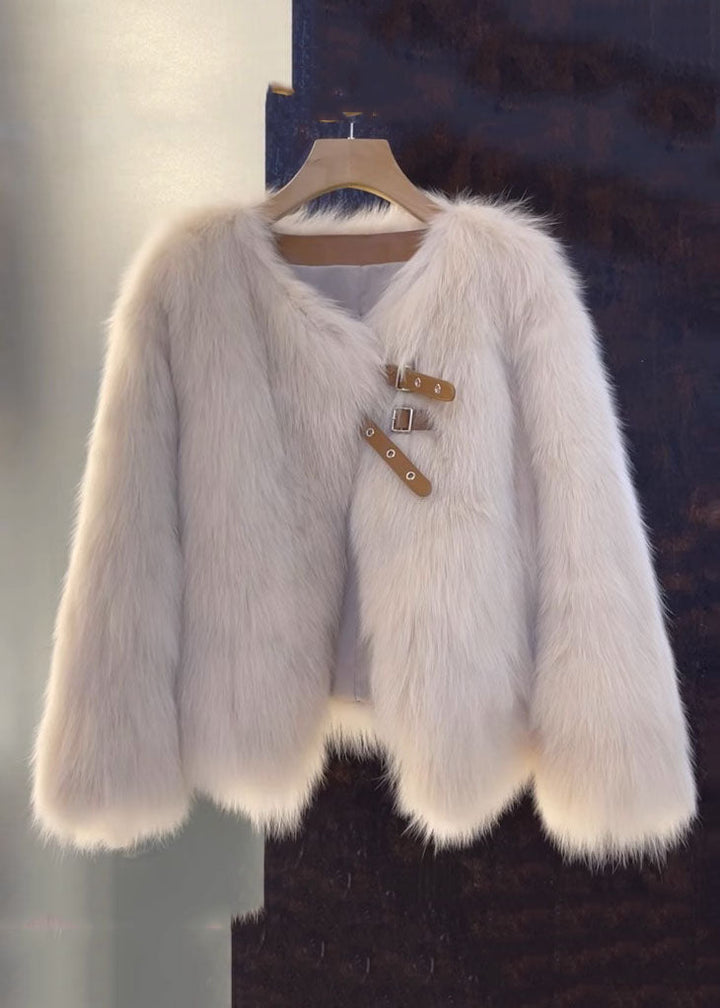 Detaljbild av v-hals läderstil rock för damer med eleganta pälsdetaljer. Lös passform ytterplagg för höst/vinter.