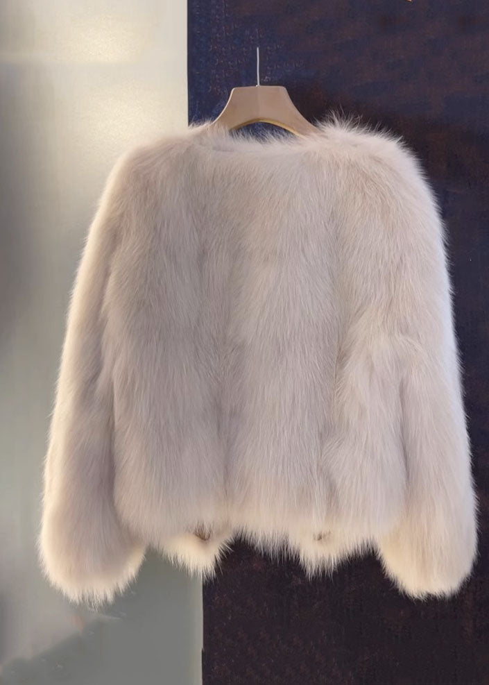 Kvinnors V-hals kappa i läderstil med eleganta pälsdetaljer. En brun/beige lös passform ytterplagg för kalla dagar.