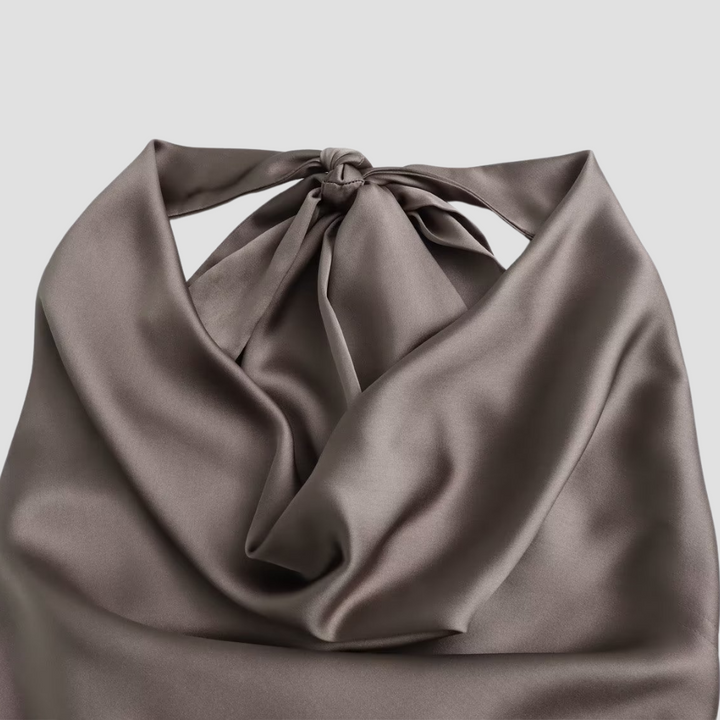 Närbild av den draperade detaljen på en brun halternecktopp för kvinnor