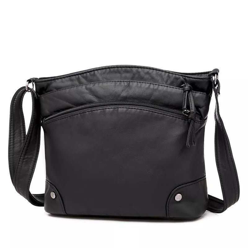 Kvinnlig modell bär stilren svart läder axelväska. Elegant accessoar, praktisk för vardag och fest.