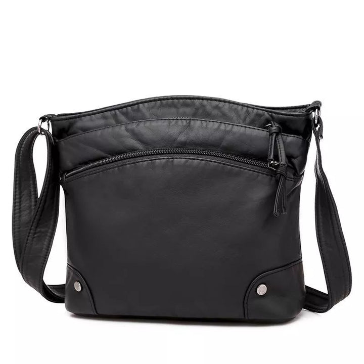 Kvinnlig modell bär stilren svart läder axelväska. Elegant accessoar, praktisk för vardag och fest.