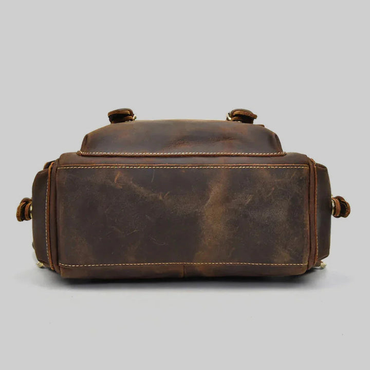 Detaljbild på elegant läderryggsäck för män. Klassisk stil och robust design i brunt läder.