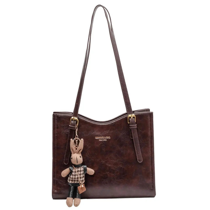 Elegant brun toteväska med charm. Rymlig damhandväska, perfekt modeaccessoar för vardagsbruk.
