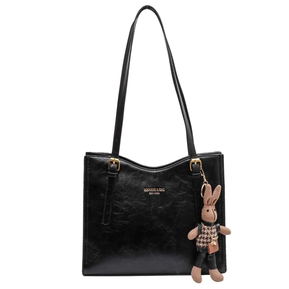 Svart elegant toteväska med dekorativ charm. En stilren och rymlig damväska för alla tillfällen.