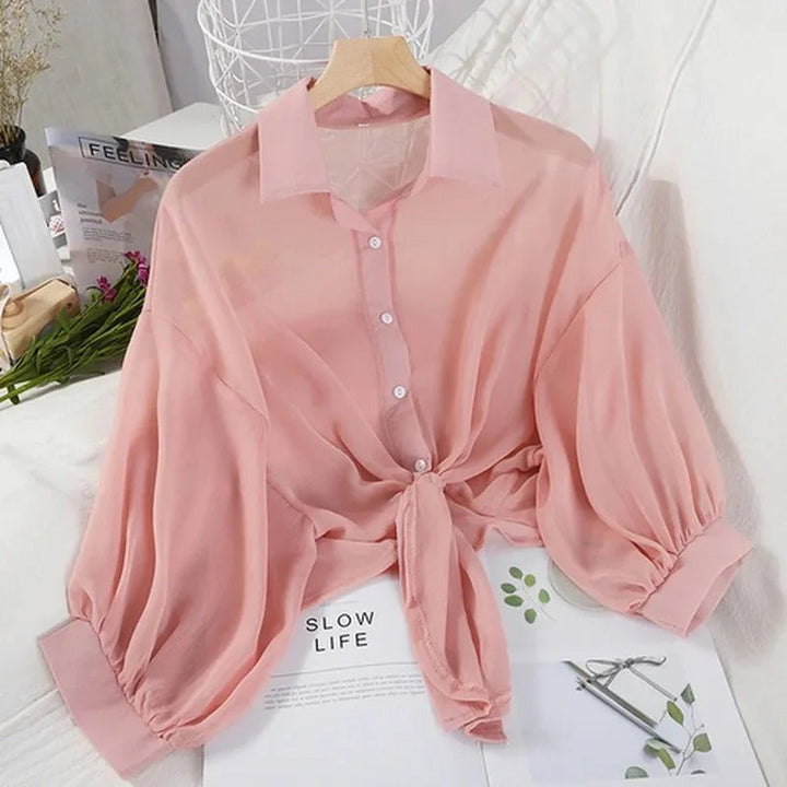 Trendig halvärmad damblus i chiffong med knuten midja, idealisk för sommarbruk.