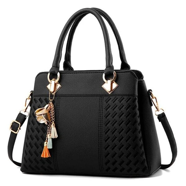 Detaljbild: Broderade blommor och snygg tofs på elegant svart crossbodyväska för damer.