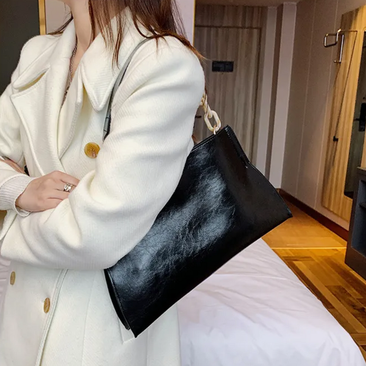 Elegant damhandväska/axelväska i konstläder. Mångsidig och justerbar, en chic accessoar för alla tillfällen.