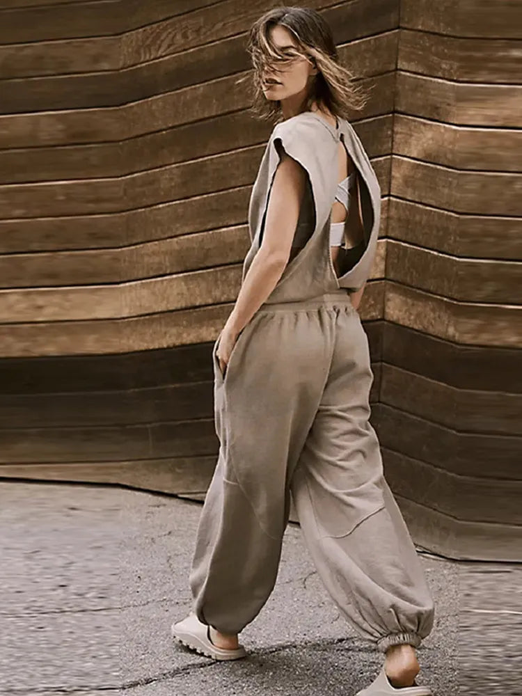 Elegant dam jumpsuit i flödande tyg med dragsko och öppen rygg. Mångsidig för både fest och vardag.