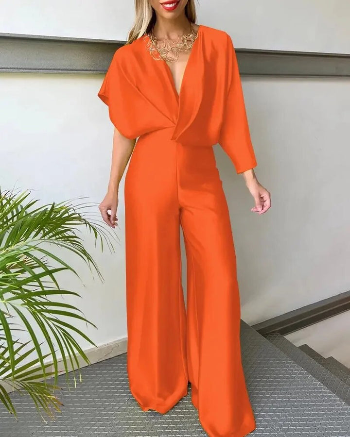 Modell bär färgglad dam jumpsuit med elegant V-hals och luftig vingärm, visar upp den bekväma passformen.