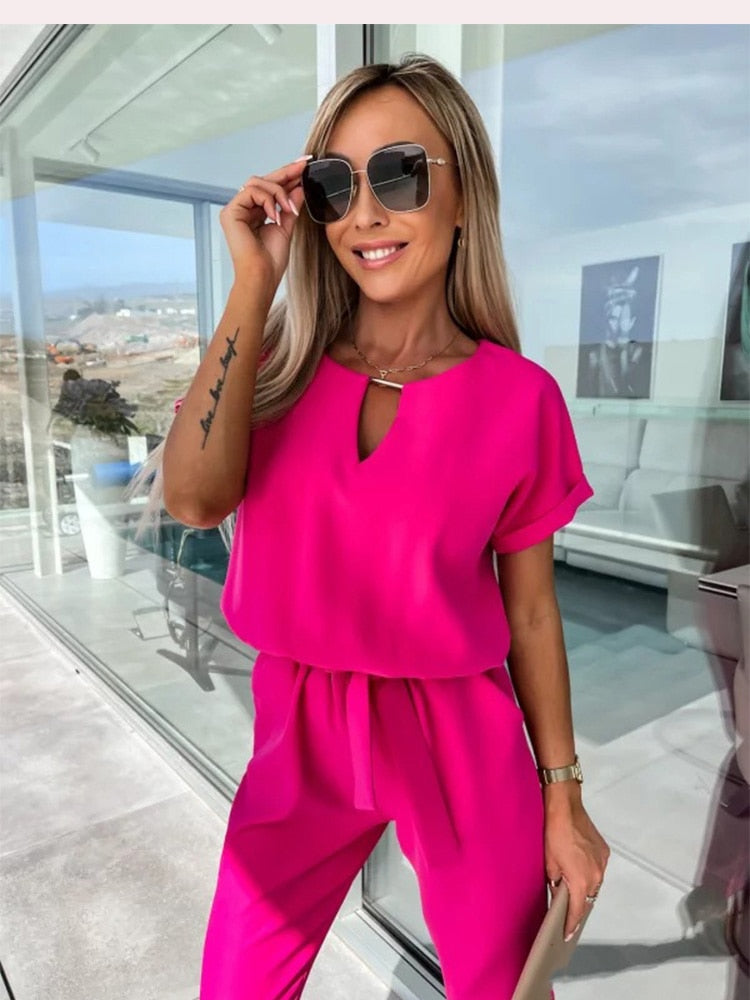 Rosa kvinnors byxdress med kort ärm och V-hals. Elegant sommarstil med elastisk midja.