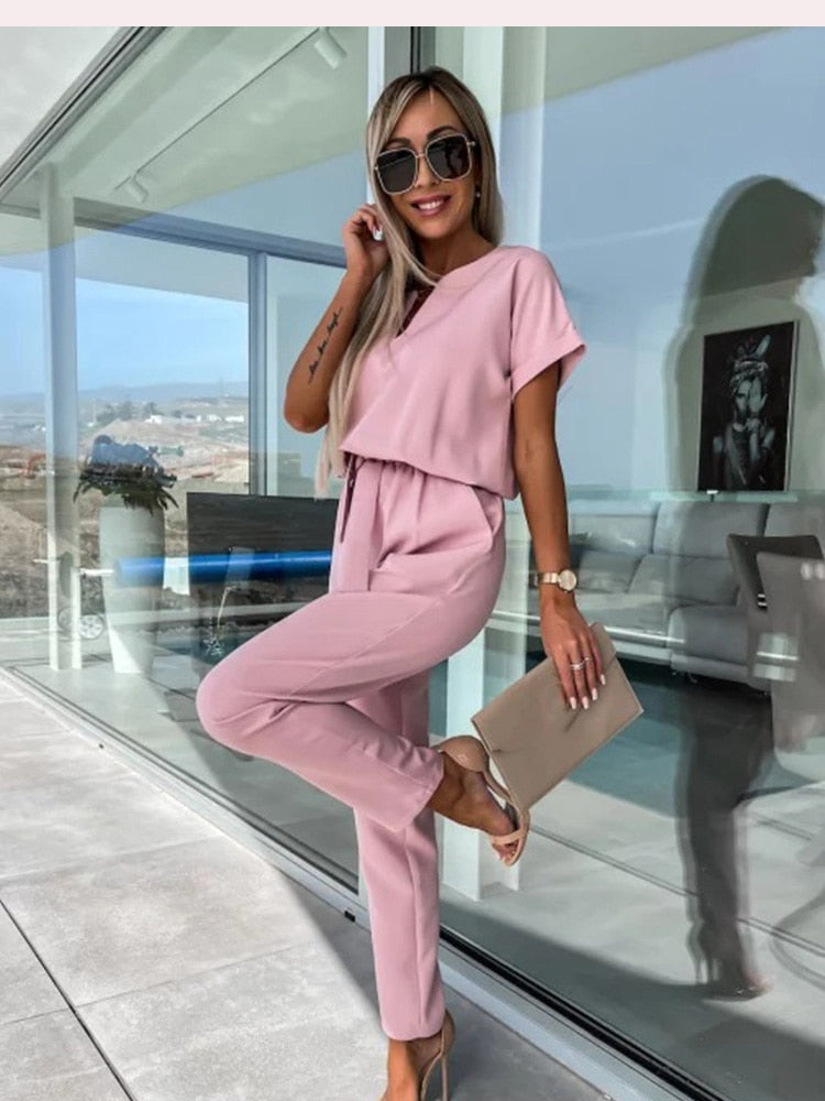 Dam jumpsuit med kort ärm, V-hals och bekväm elastisk midja. Finns i svart, rosa & kaki.