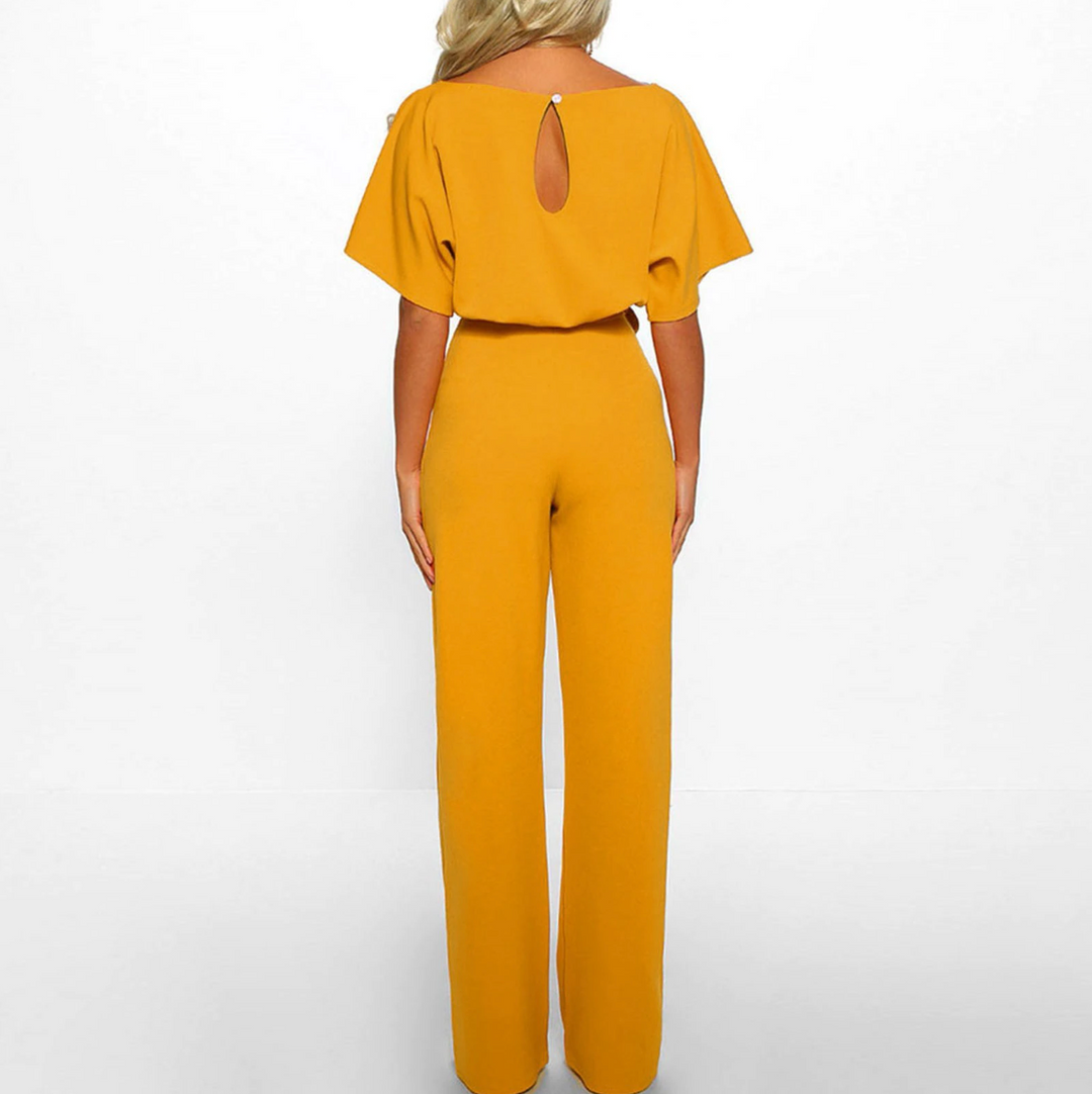 Bekväm beige dam jumpsuit med vida ben och kort ärm. En elegant byxdress för varmare dagar.