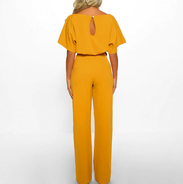Bekväm beige dam jumpsuit med vida ben och kort ärm. En elegant byxdress för varmare dagar.