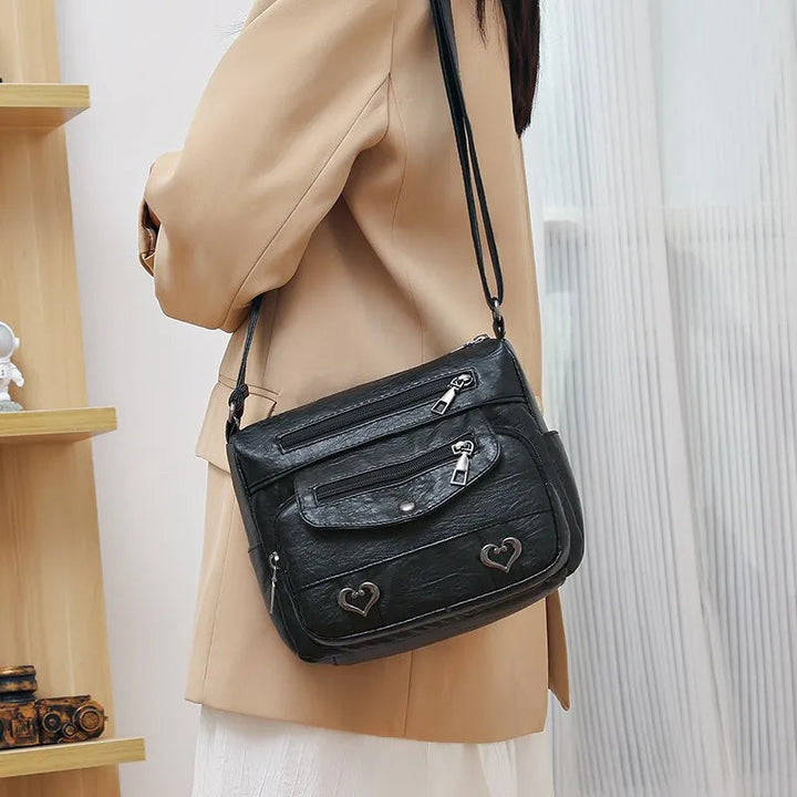 Stilren svart crossbodyväska, messenger-stil för kvinnor. Praktisk och elegant modeaccessoar.