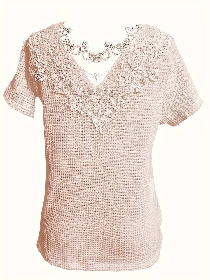 Elegant dam t-shirt med spetsdetaljer. Stilren topp för vardagsmode & fest.