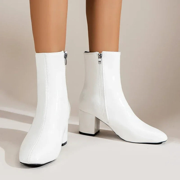Kvinnors ankelboots med praktisk sidodragkedja, blockklack och spetsig tå för enkel komfort.