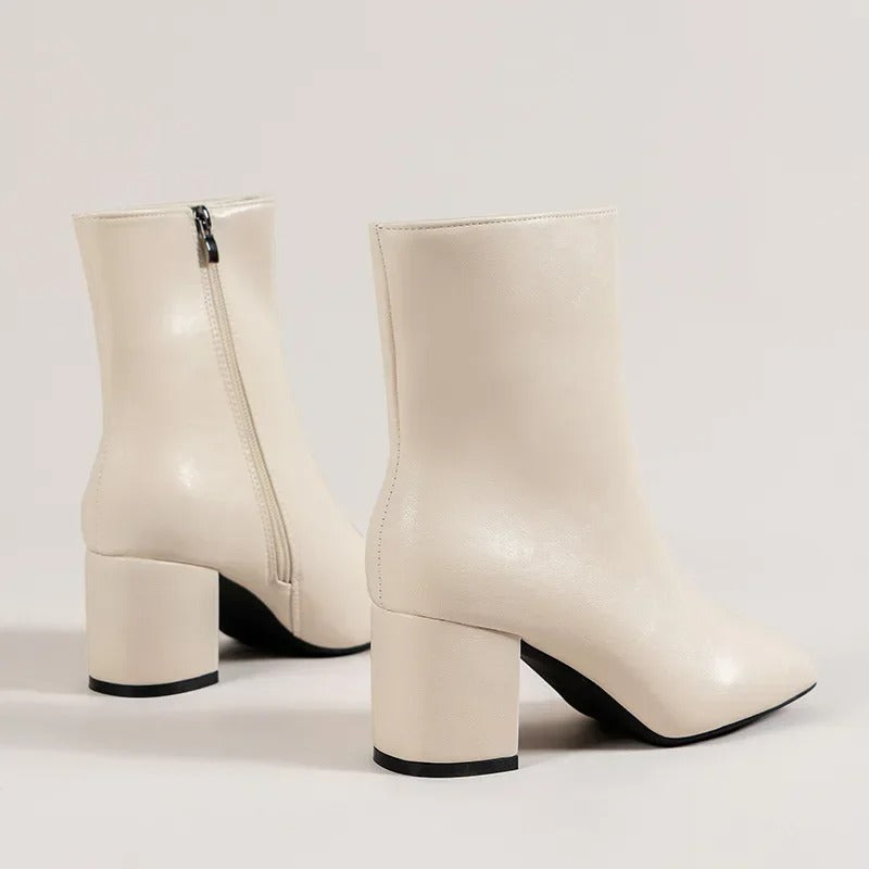 Kvinna bär eleganta damankelboots med blockklack och spetsig tå, perfekt för daglig stil.