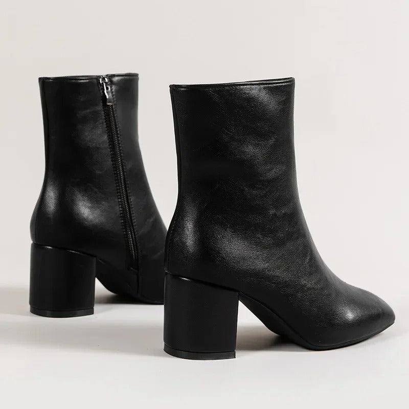 Ett par svarta damankelboots med blockklack, spetsig tå och sidodragkedja. Eleganta modeboots.