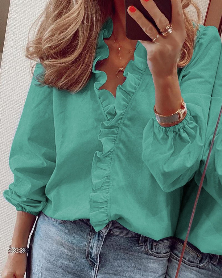 Modell bär elegant damblus, perfekt för formella event. Stilfull och bekväm för kontoret eller fest på vår/höst.