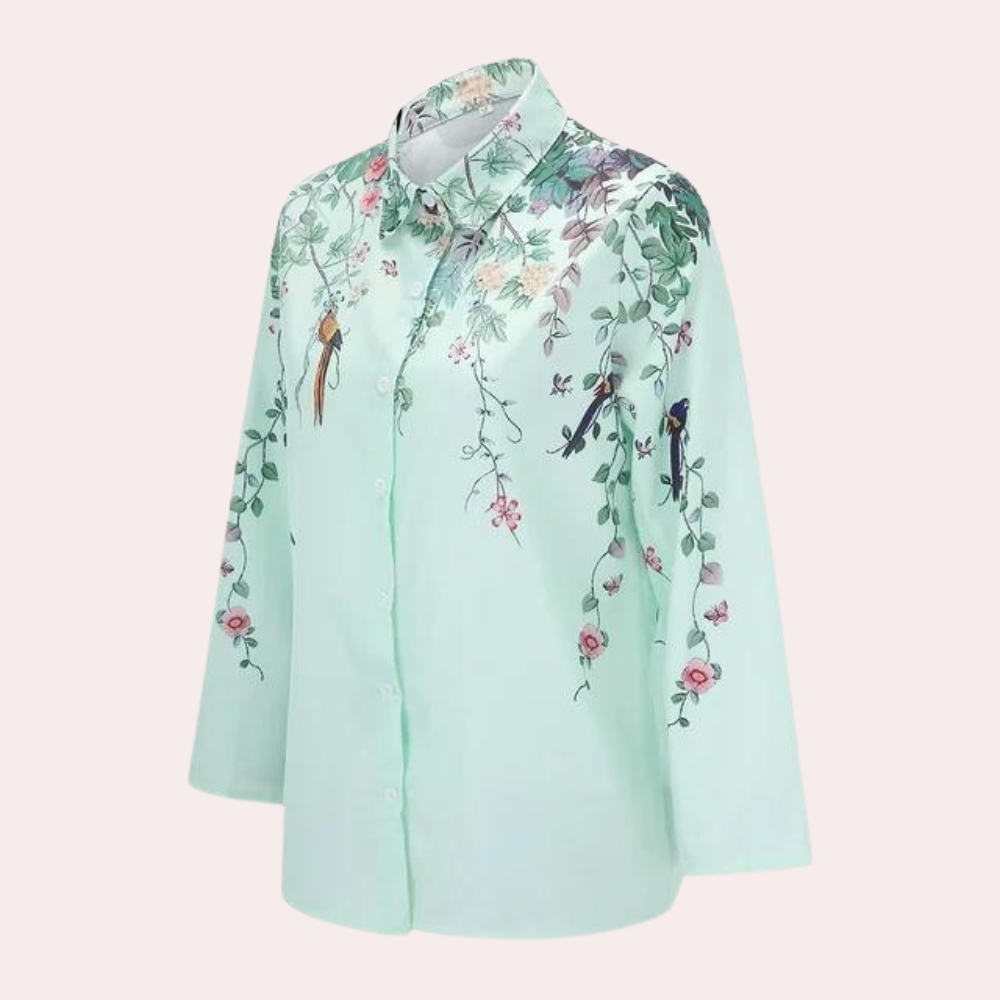 Modell bär blombroscherad damblus med voluminösa puffärmar, perfekt för sommaren.