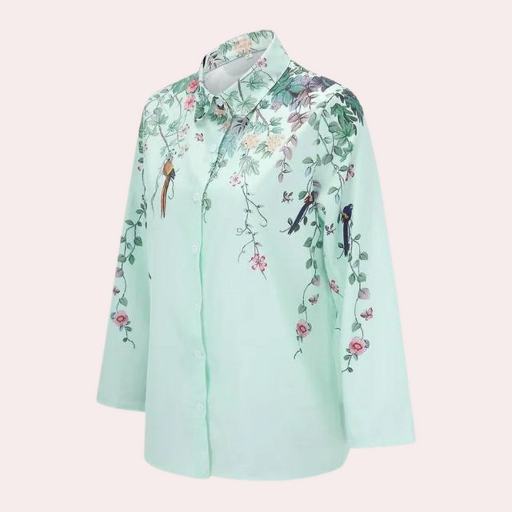 Modell bär blombroscherad damblus med voluminösa puffärmar, perfekt för sommaren.