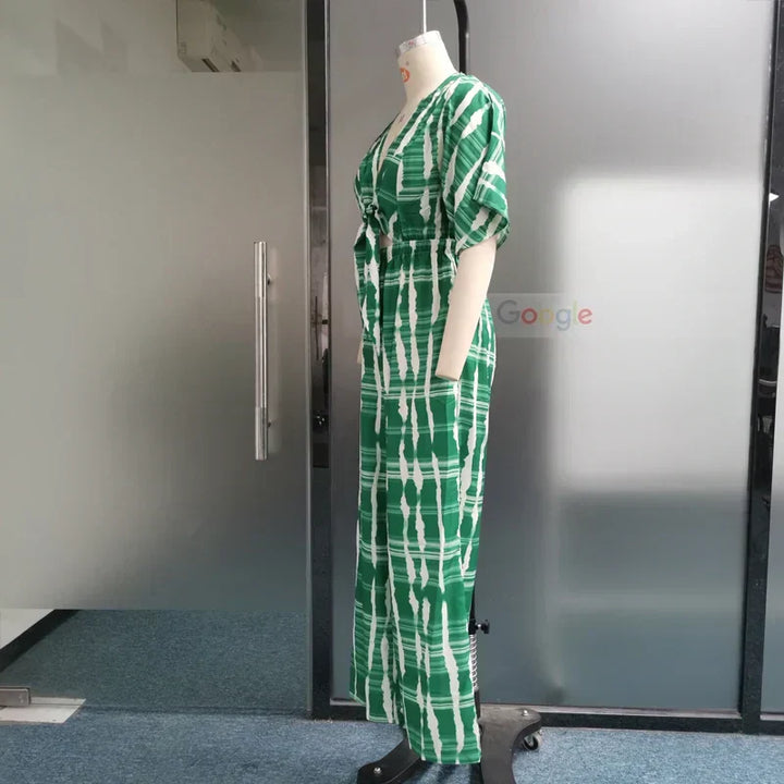Flödande blå damjumpsuit med djup V-ringning, vida ben. Stilren och bekväm för både fest och fritid.