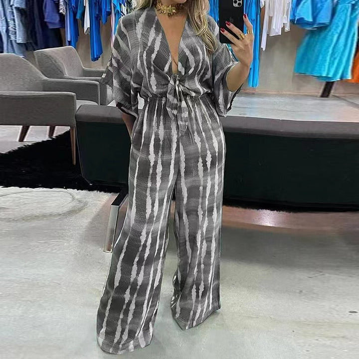 Damjumpsuit med djup V-ringning och vida byxben. En elegant och modern byxdress för sommarens festligheter.