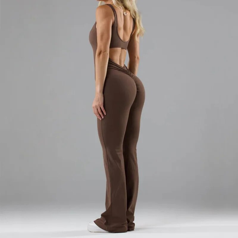 Modell som visar rygglösa detaljen på den svarta damjumpsuiten med blommiga byxben, elegant look.